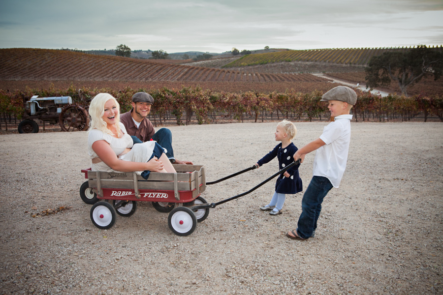 parents in wagons with kids pulling in vineyard